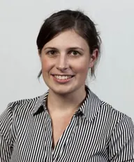 Kelly Clanchy in a striped shirt, smiling.