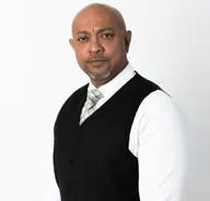 Lesh Prasad in a white shirt and black waistcoat.