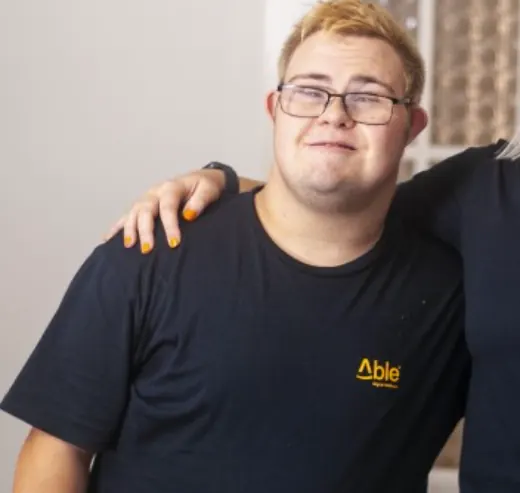 Aaron in an Able t-shirt, smiling.