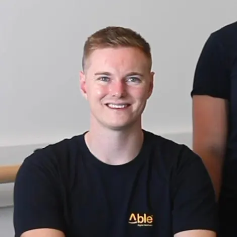 Mat in a black Able t-shirt, smiling.