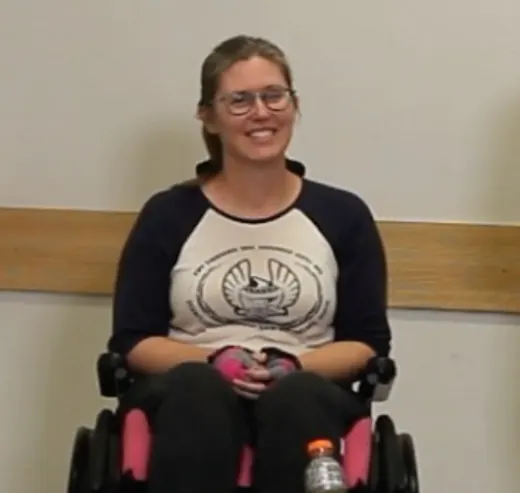 Sarah in her wheelchair, smiling.